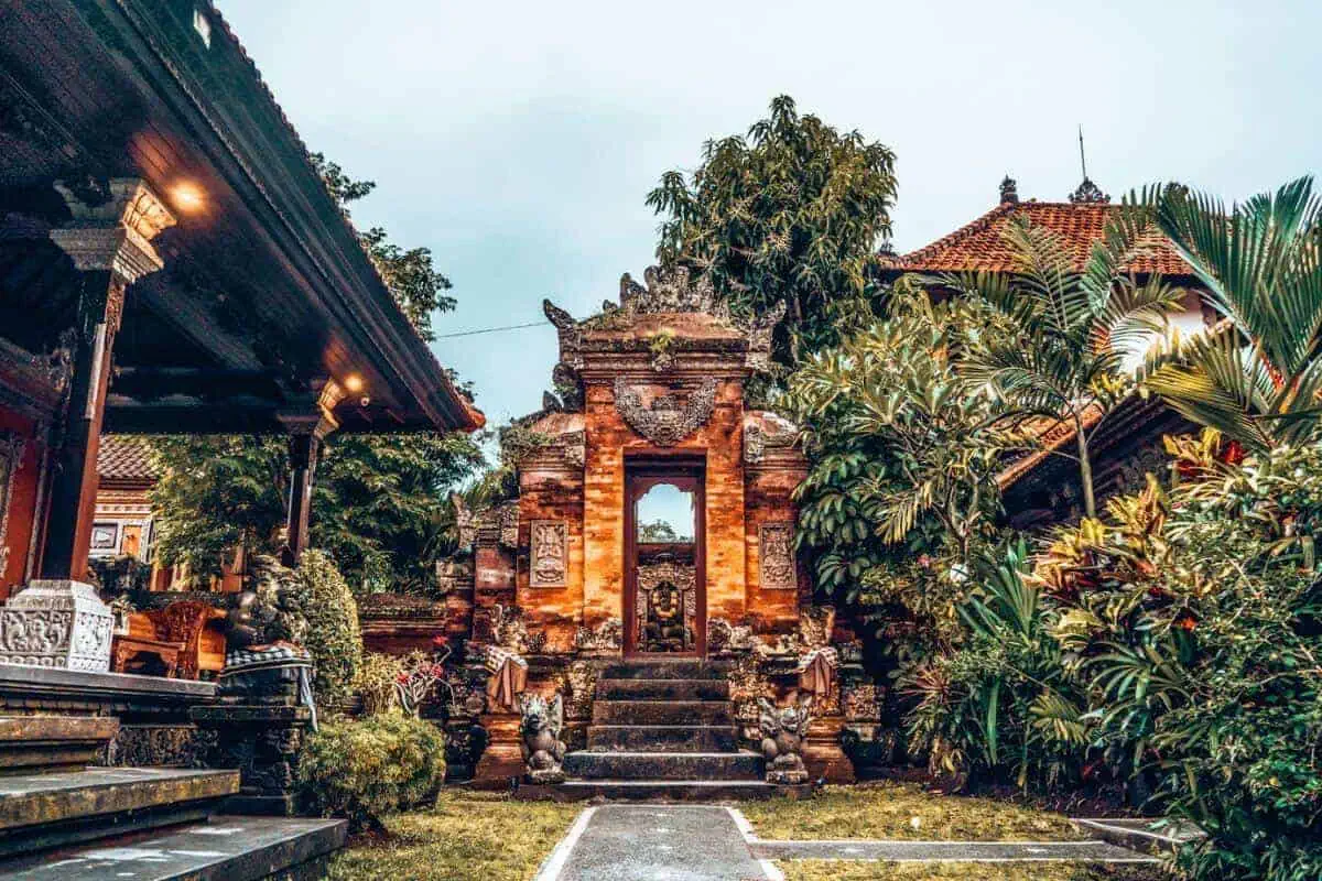 An ornate and traditional Balinese temple and gate in Ubud, surrounded by greenery