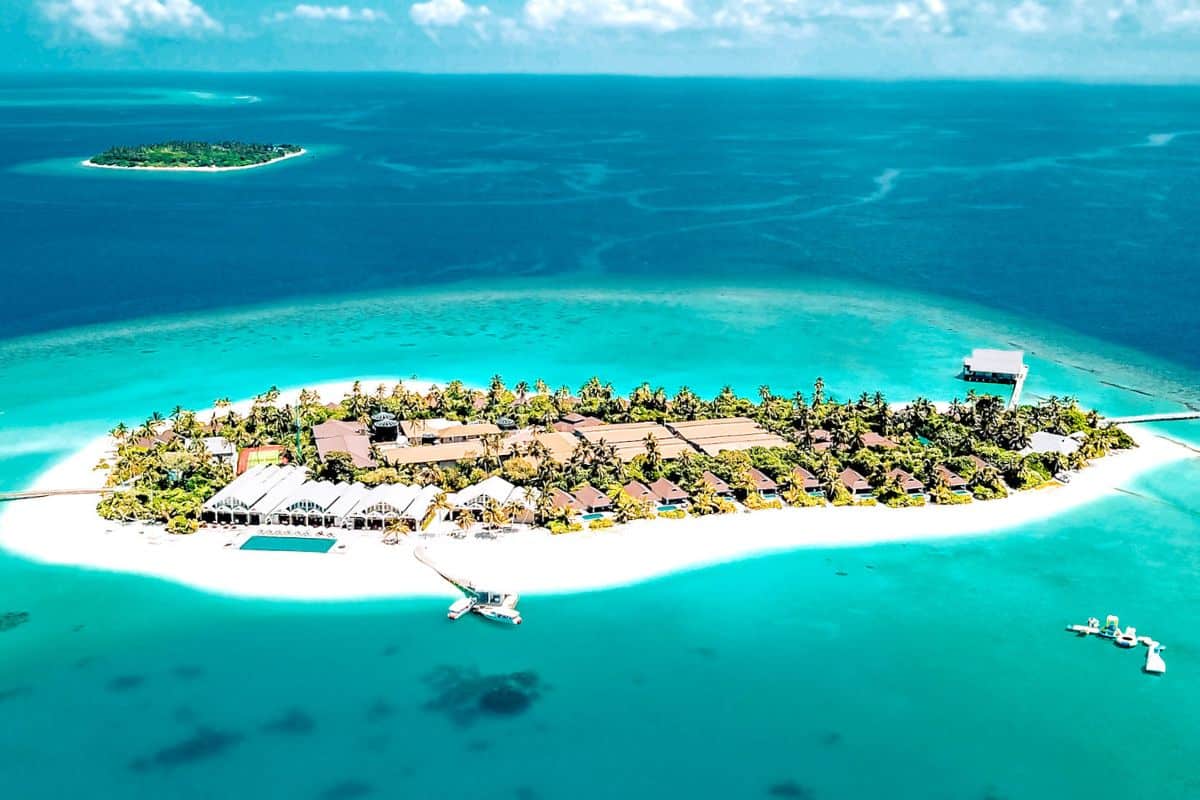 An aerial view of a small, private island resort in the Maldives