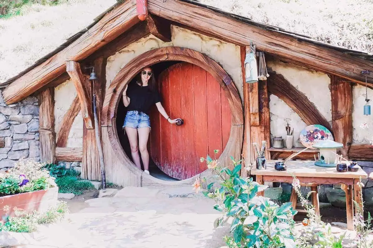 Hannah standing in the doorway of a hobbit house in Hobbiton, New Zealand