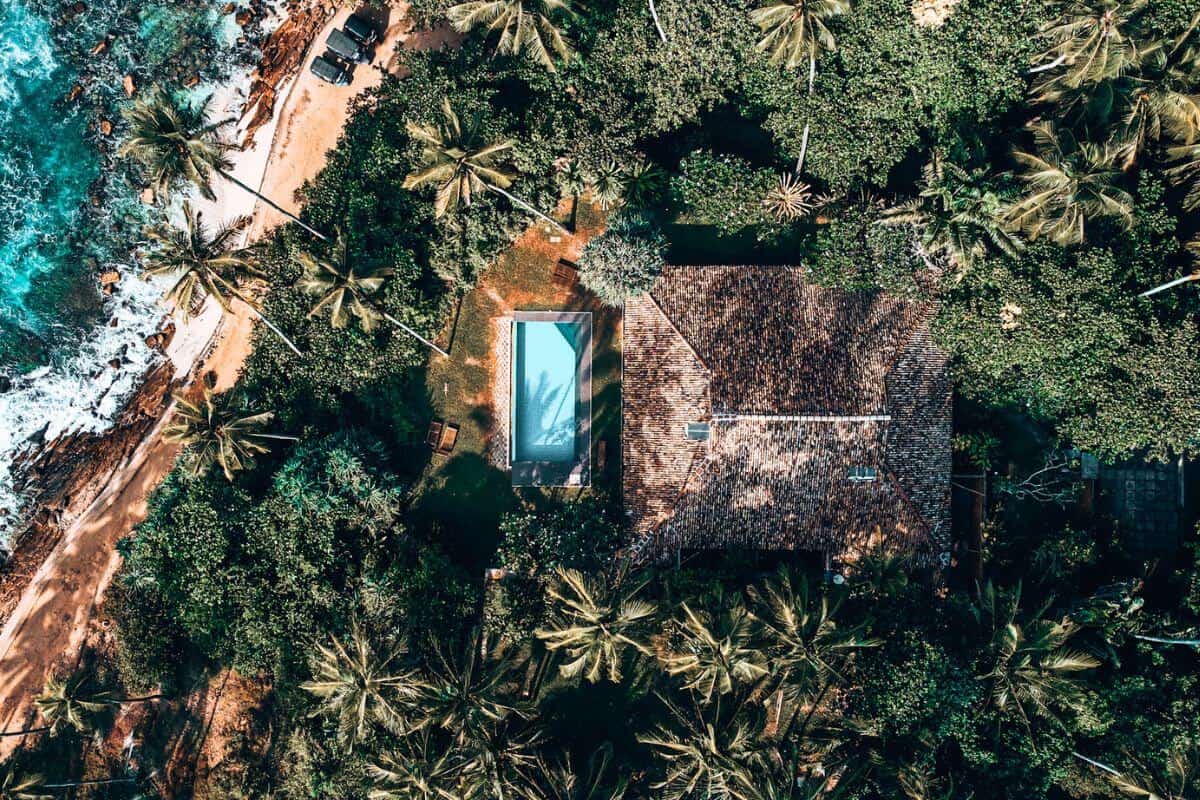 An aerial view of a villa set amongst dense tropical jungle by the sea in Sri Lanka