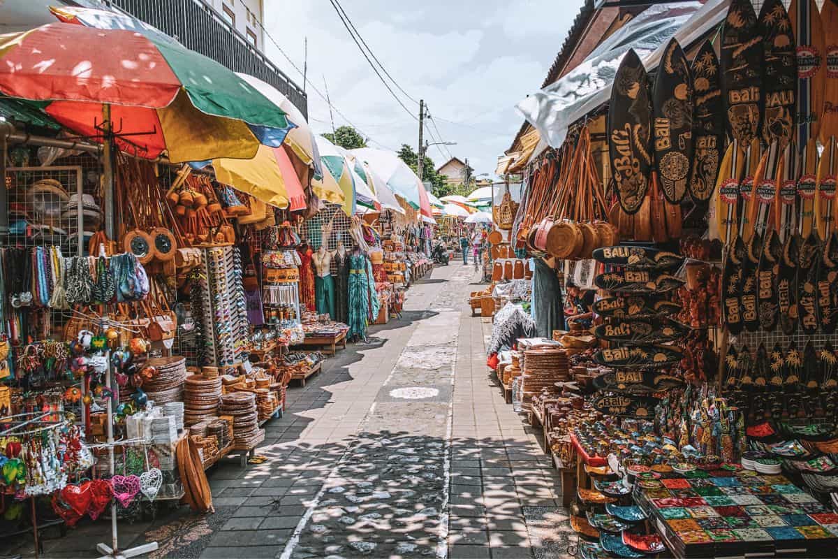 A street filled with market stalls selling souvenirs and crafts at a traditional market in Ubud, Bali