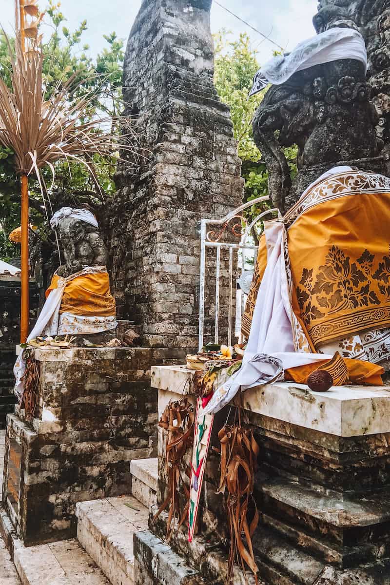 Two stone statues guarding the entrance gate to Uluwatu Temple in Bali