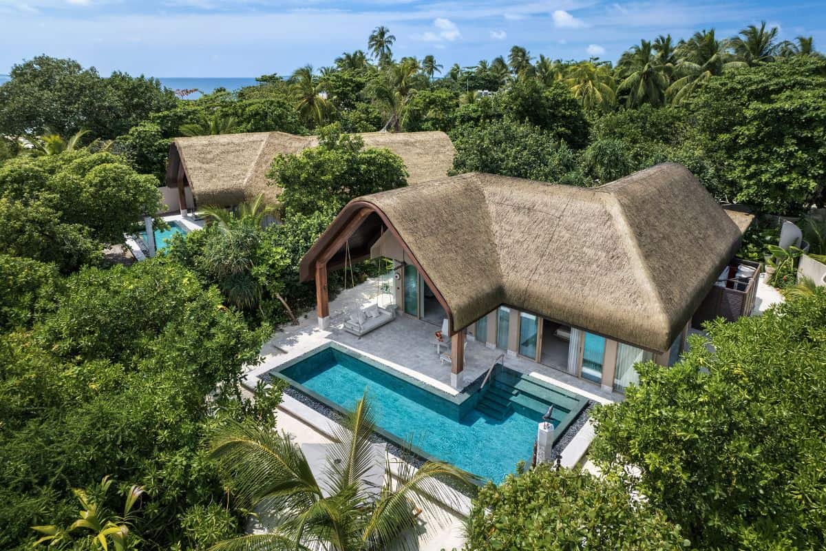 A thatched Maldivian villa nestled in tropical greenery with a private pool at Joali Being resort