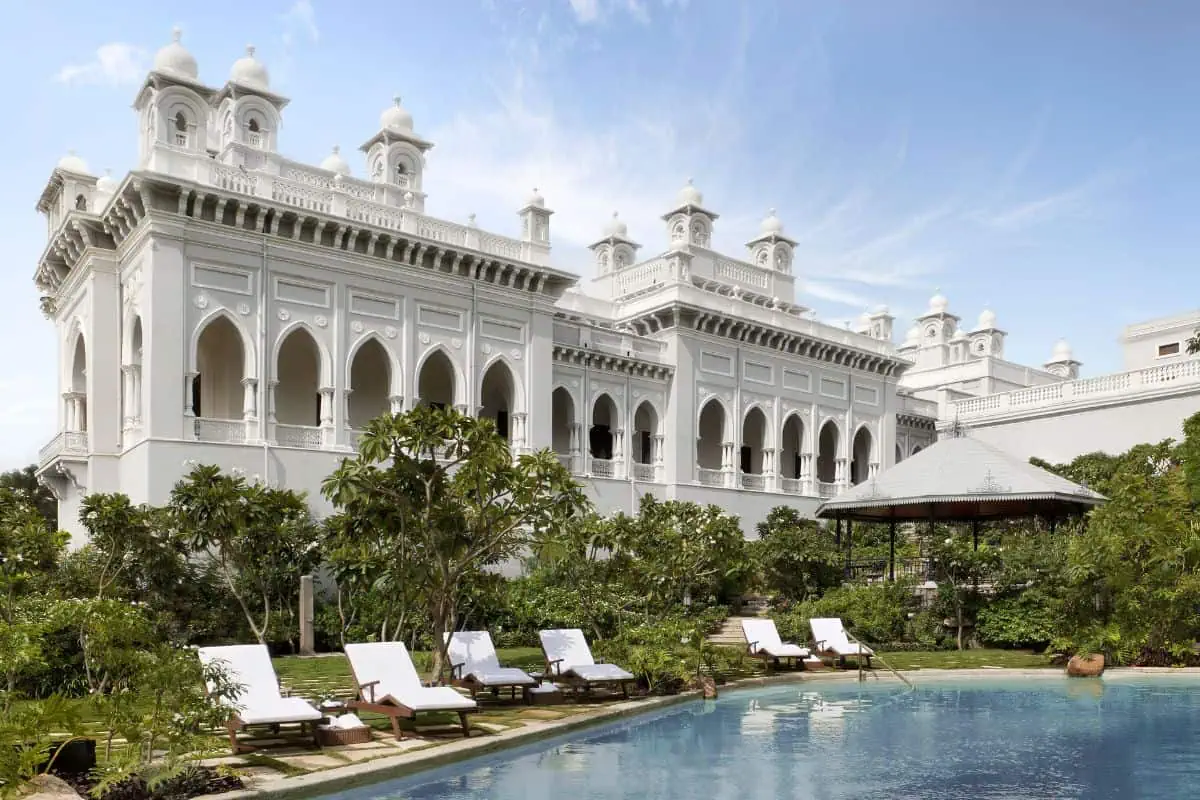 A swimming pool and sun loungers at a grand palace hotel in India