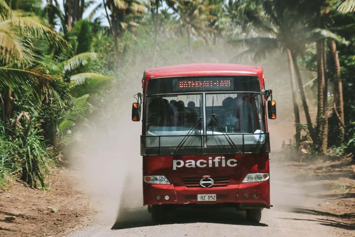 A red bus travelling through tropical scenery on Fiji's Taveuni Island