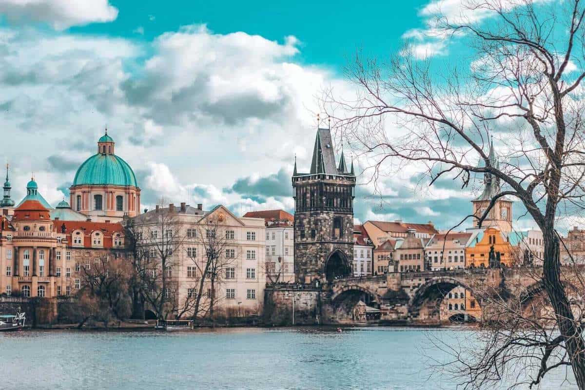 View across the river towards Charles Bridge in Prague framed by winter trees