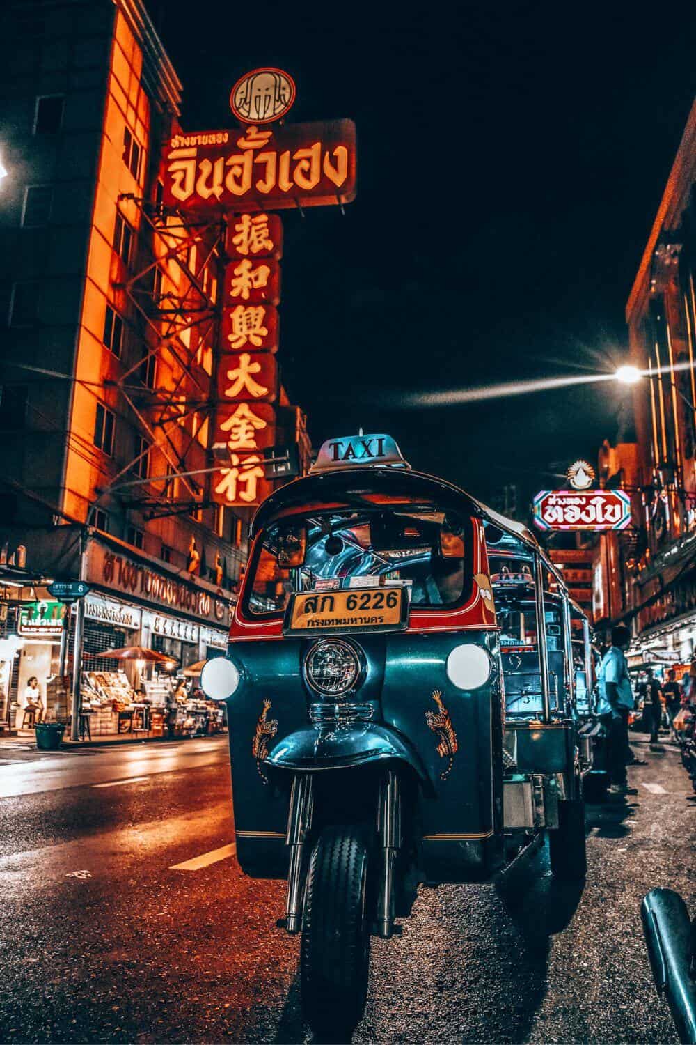 A tuk-tuk on the road in Bangkok at night
