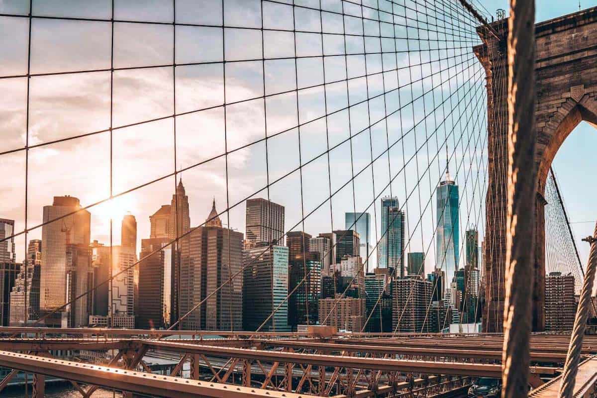 A view towards skyscrapers in Manhattan taken from the Brooklyn Bridge at sunset