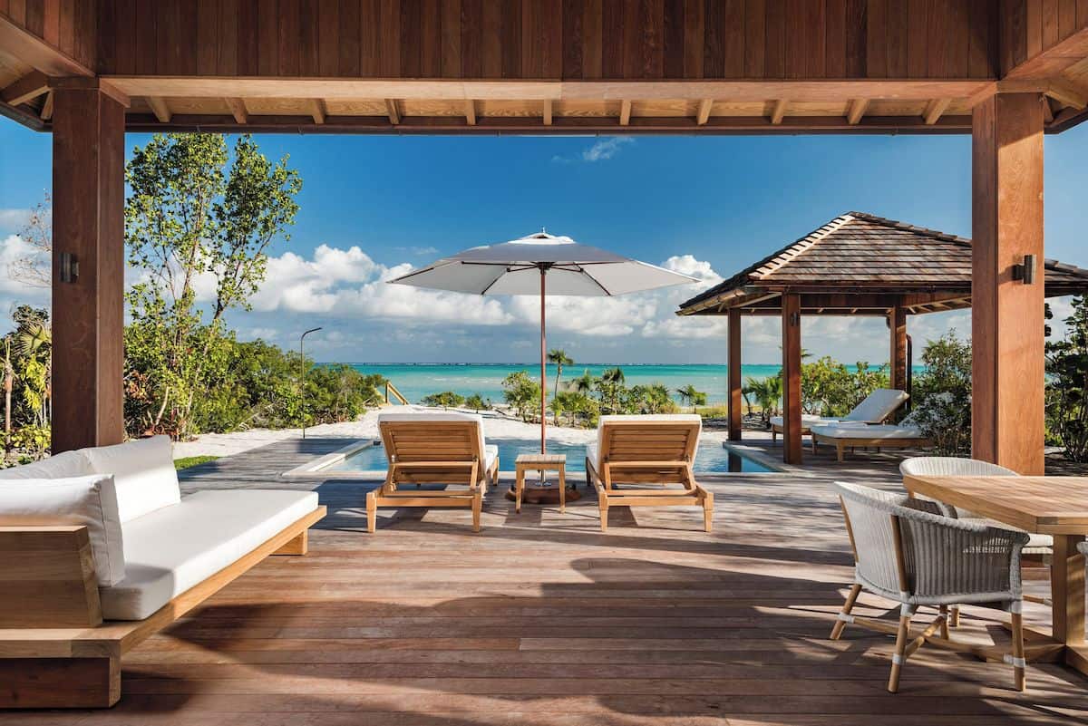 Sun loungers and a swimming pool on decking overlooking the Caribbean Sea