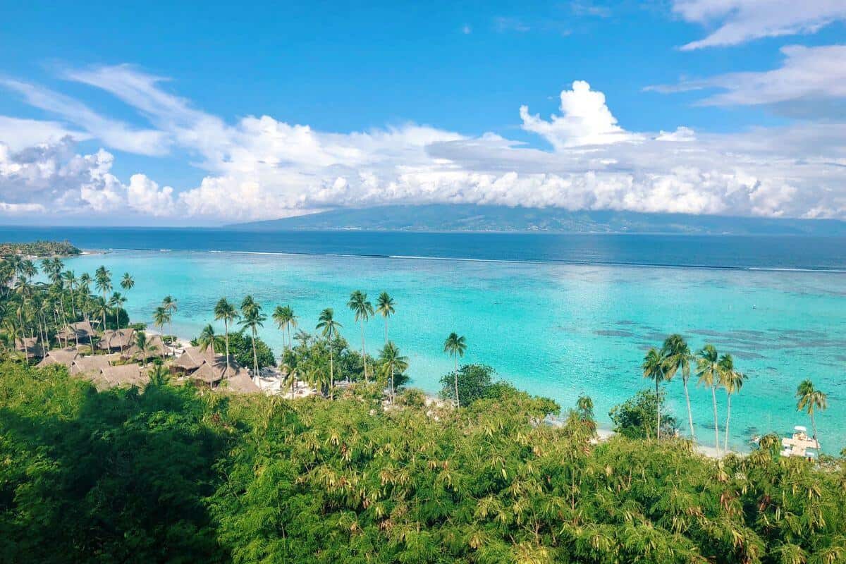 A view across a tropical island in French Polynesia towards turquoise sea