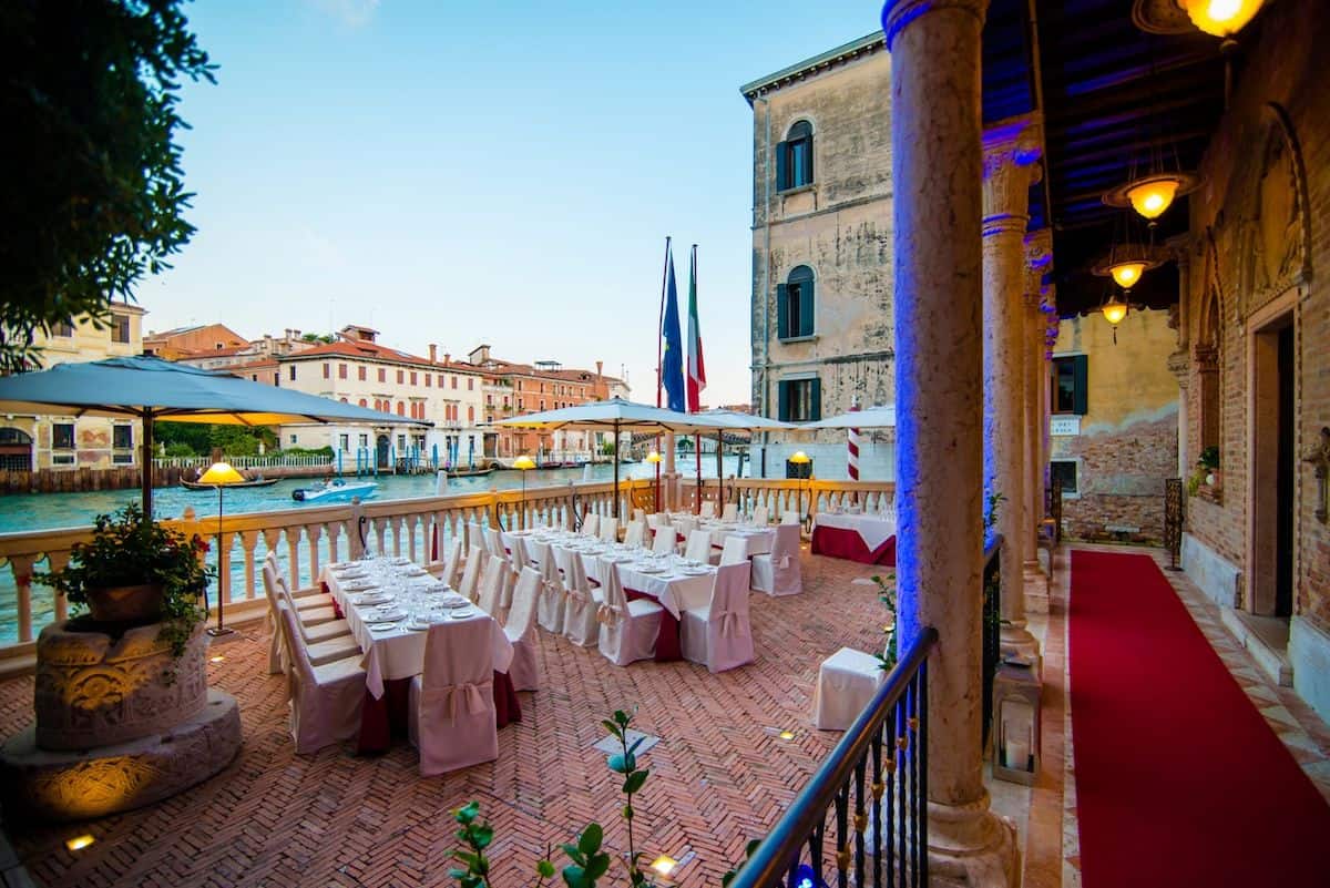 A hotel dining terrace alongside a canal in Venice