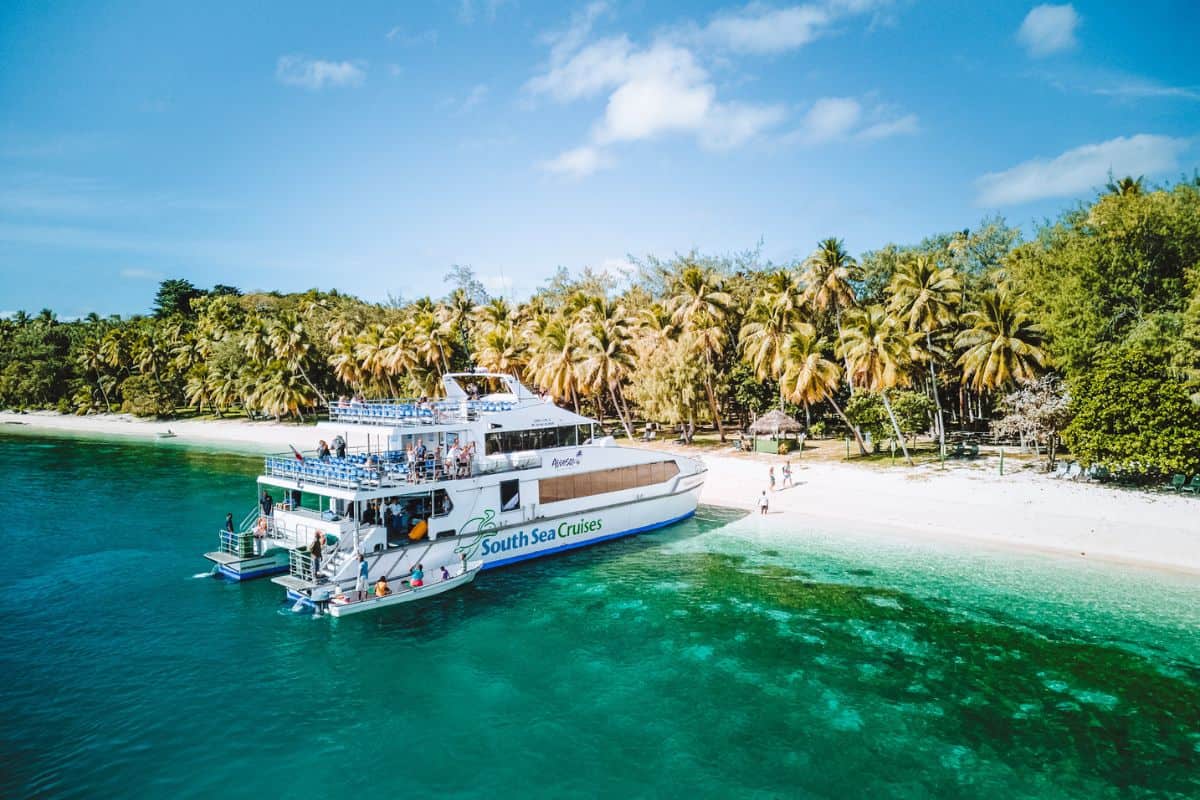 A catamaran tourist ferry in Fiji moored on the beach at a tropical island