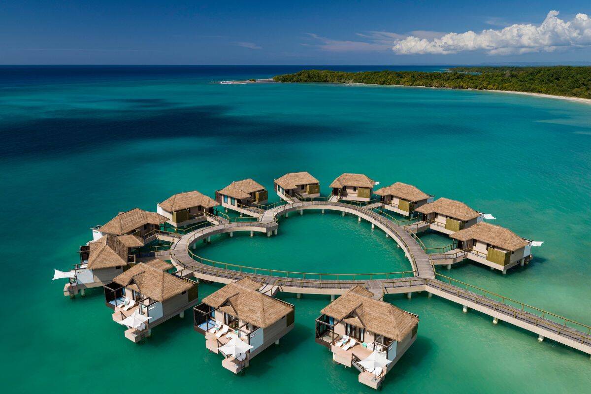 A collection of overwater bungalows in a heart shape at a resort in the Caribbean