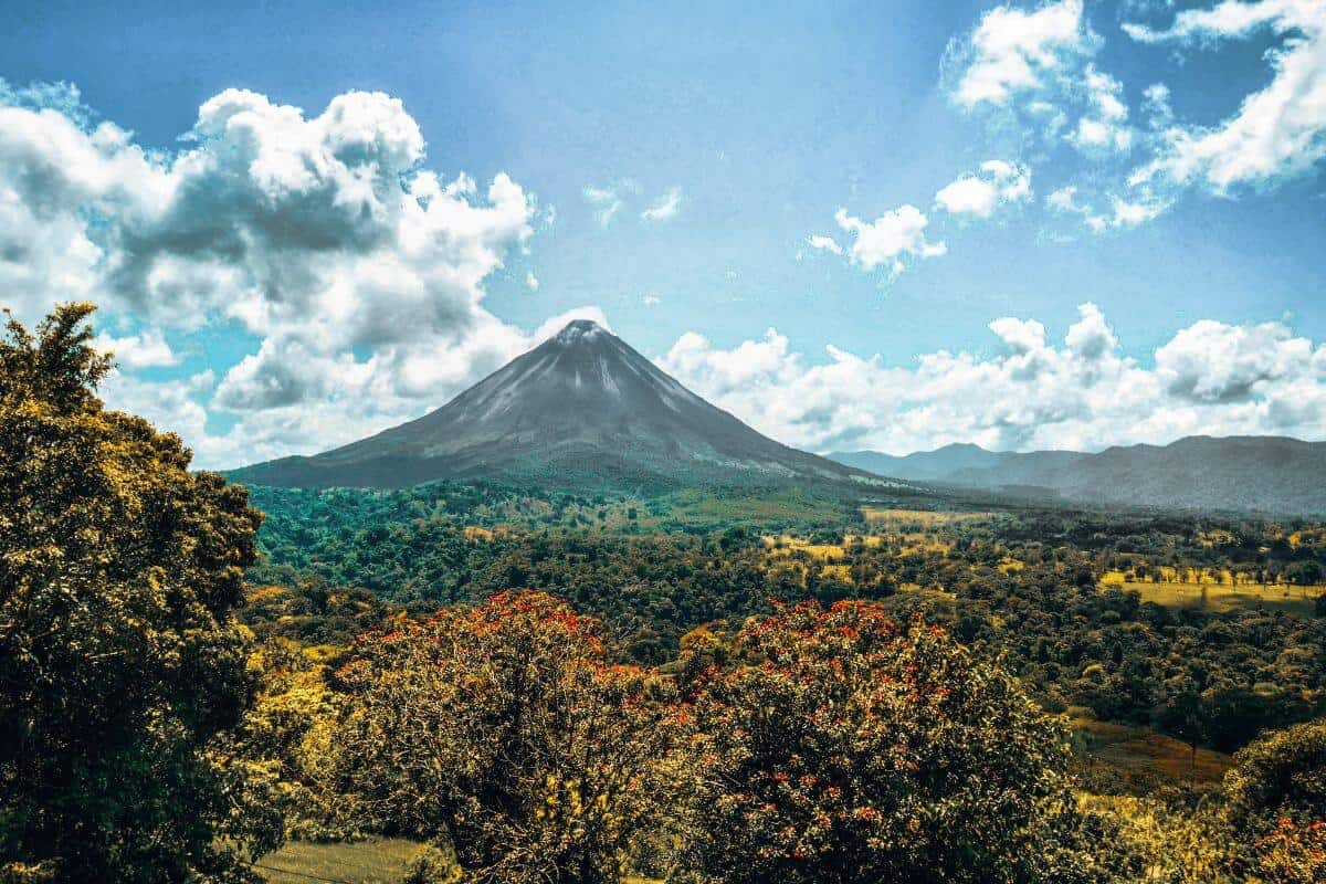 A view across rural landscapes with a volcano in the background
