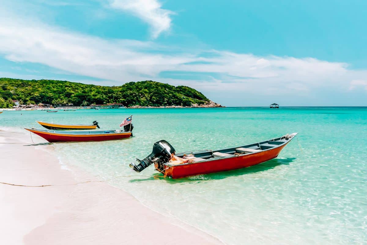 Two small boats on a white-sand beach in Malaysia