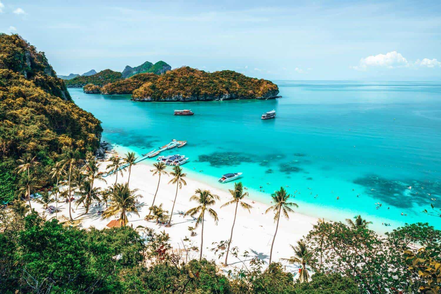 A view looking out towards turquoise sea, white sands and islands around Koh Samui, Thailand