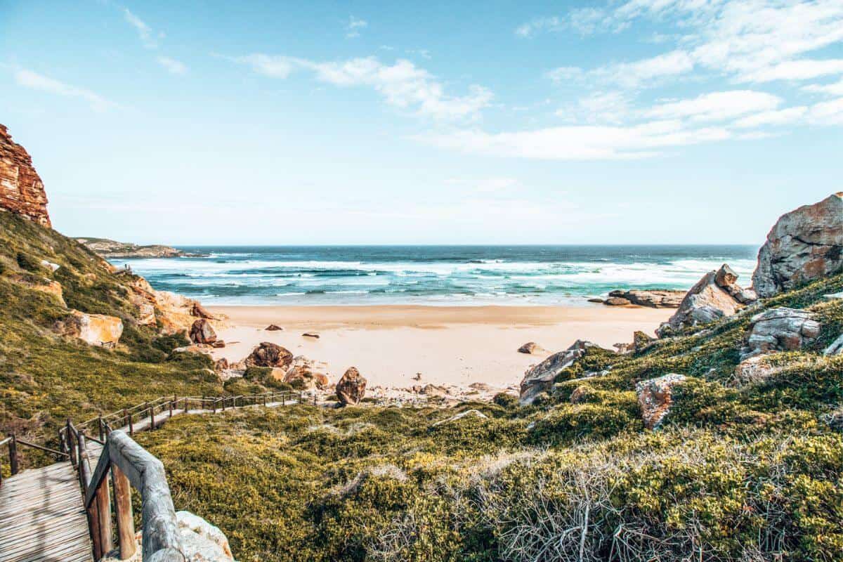 Secluded golden beach in South Africa with rocky cliffs and greenery