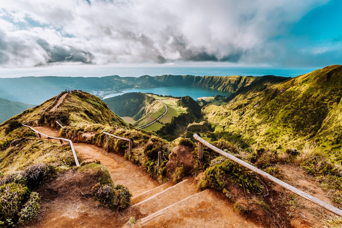 Stunning coastal landscape in the Azores with hiking trail, green hills, and ocean in the distance