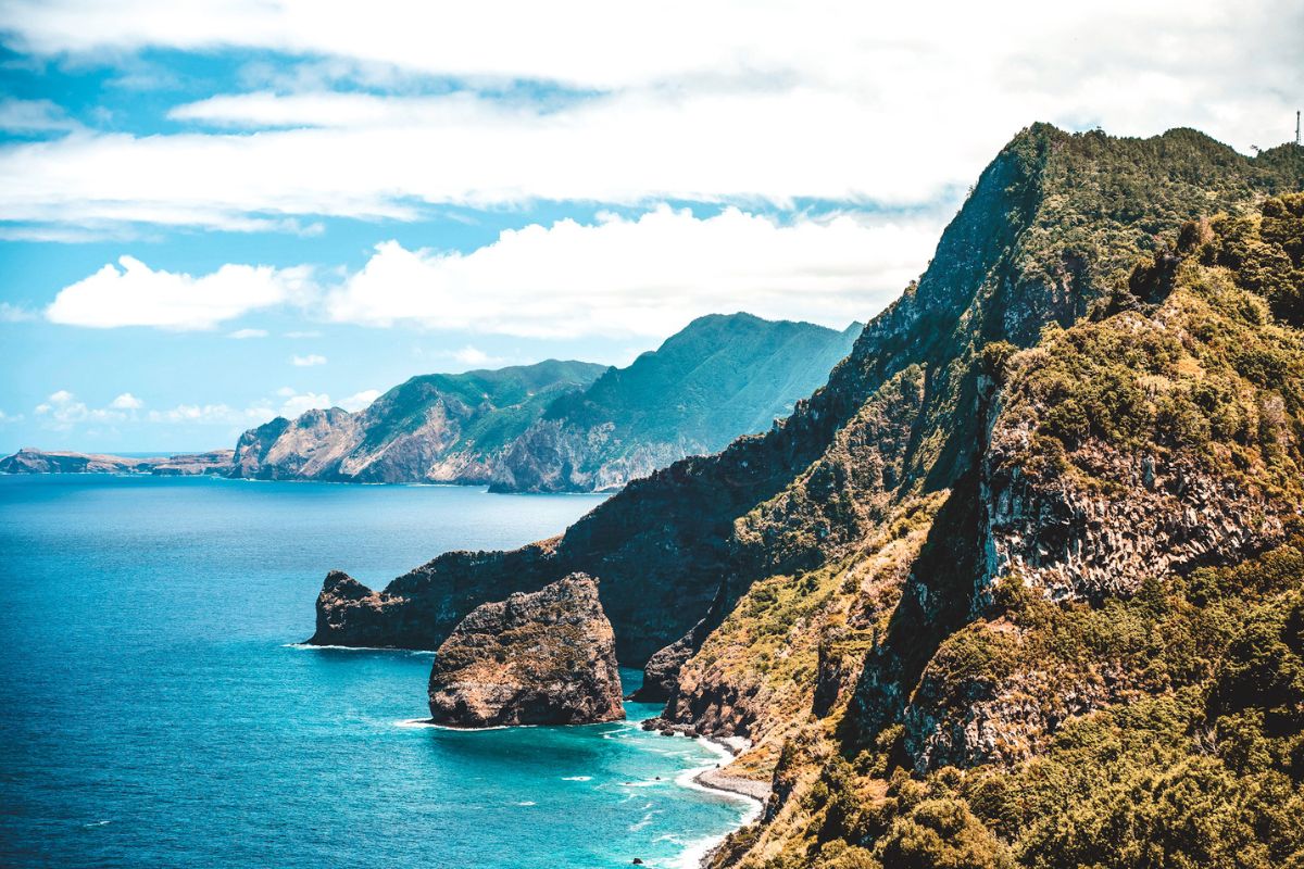Rugged cliffs along a vibrant blue ocean backdrop in Madeira, Portugal