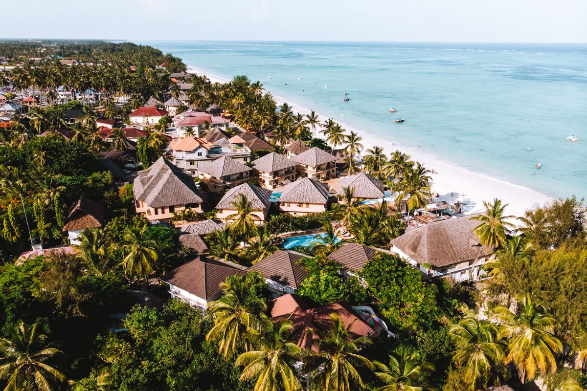 Aerial view of beachfront accommodation with tropical gardens and clear blue sea