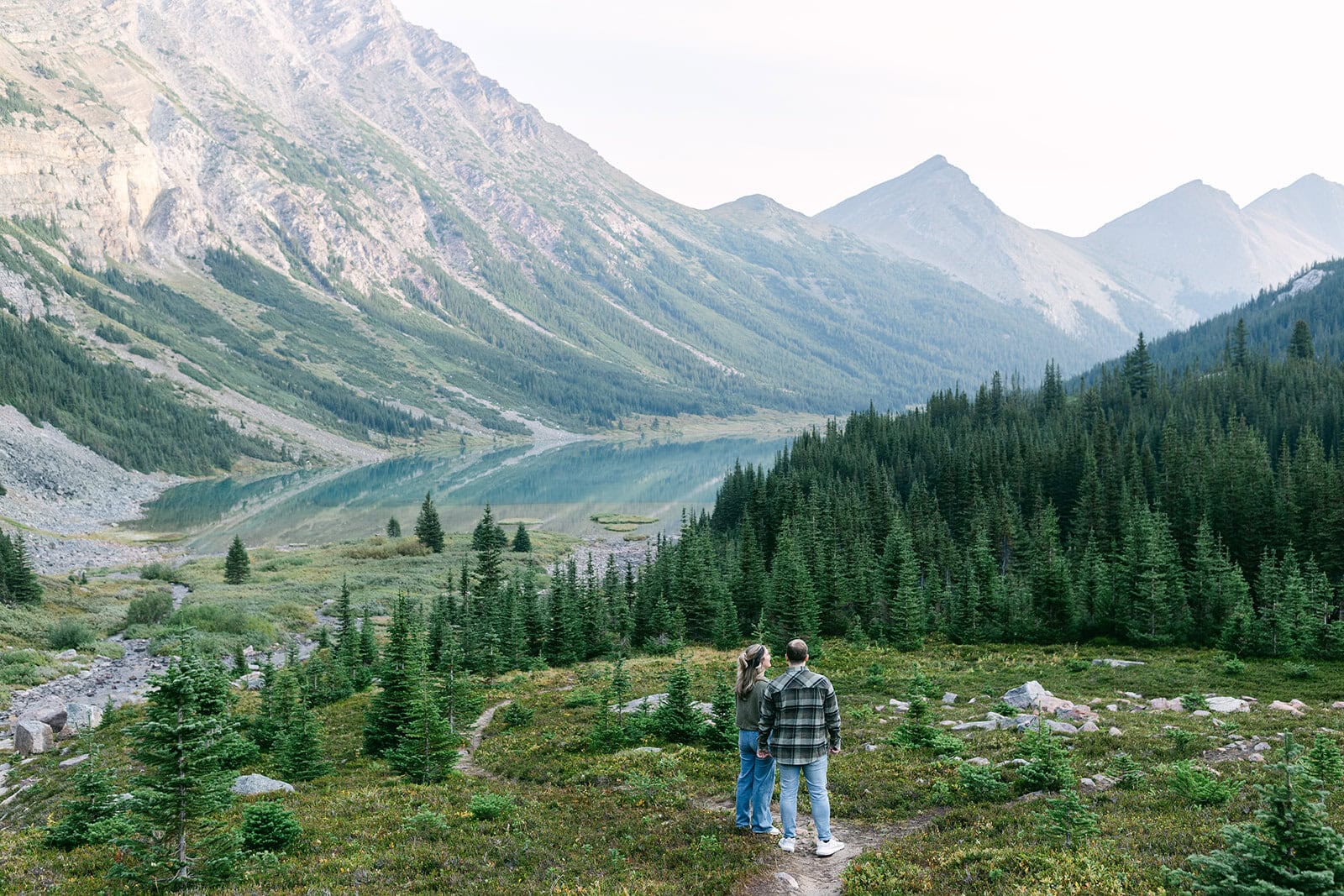 Cinematic Banff proposal moment with wide mountain valley views