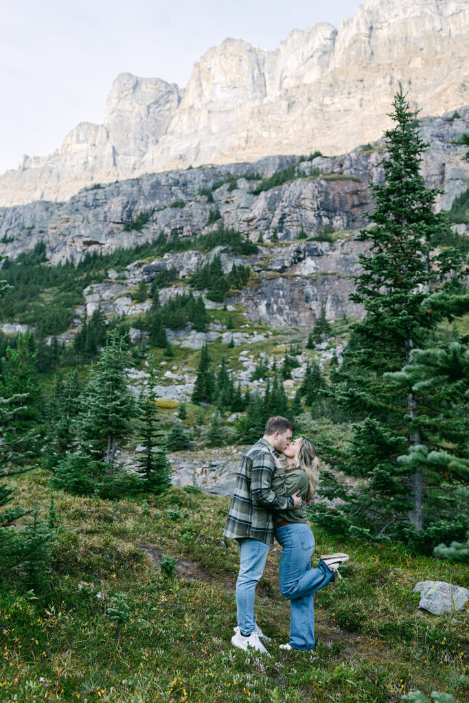 Dreamy heli proposal with a couple overlooking vast mountain landscapes after a helicopter tour