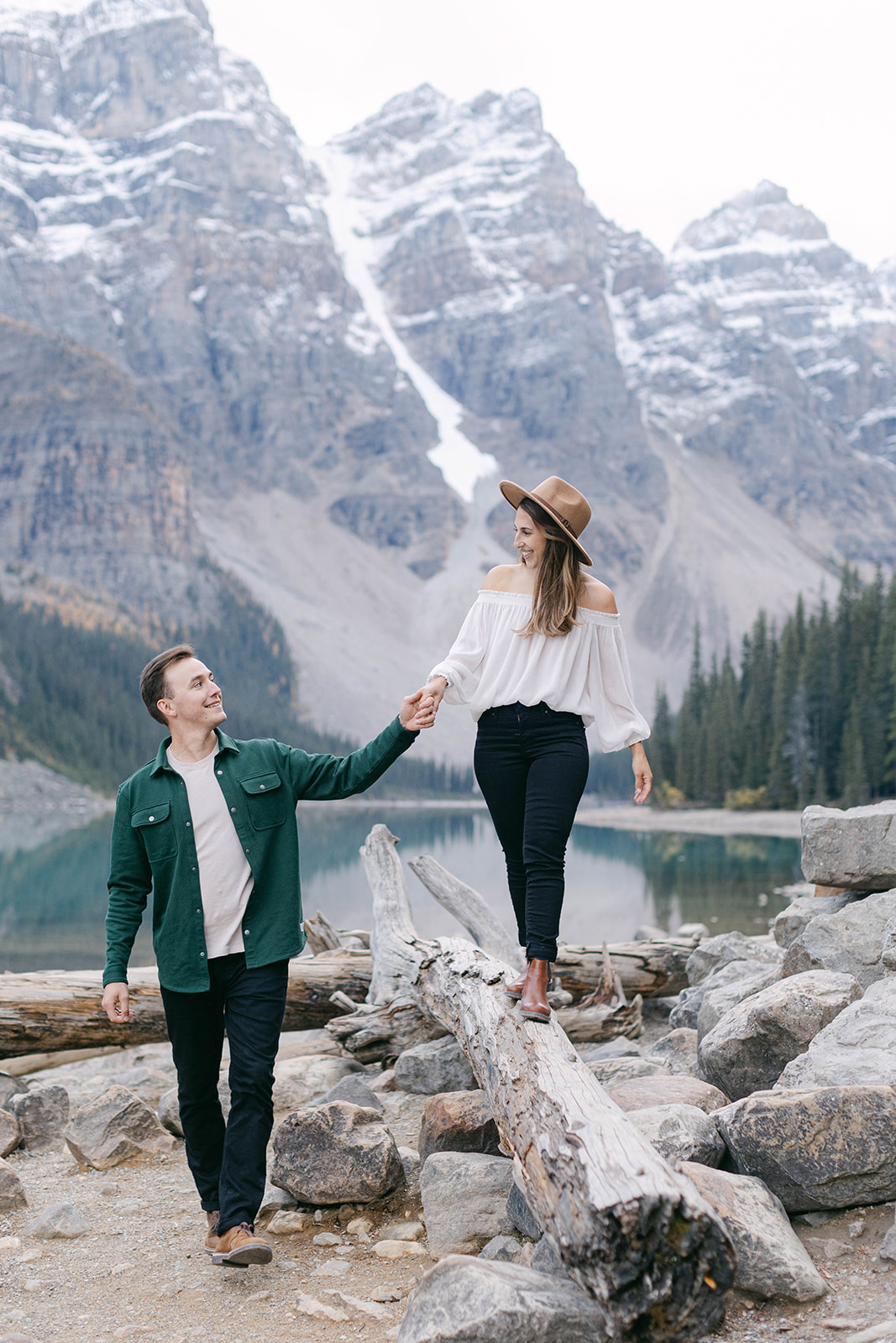Banff engagement photographer capturing a couple by a turquoise lake in the Canadian Rockies