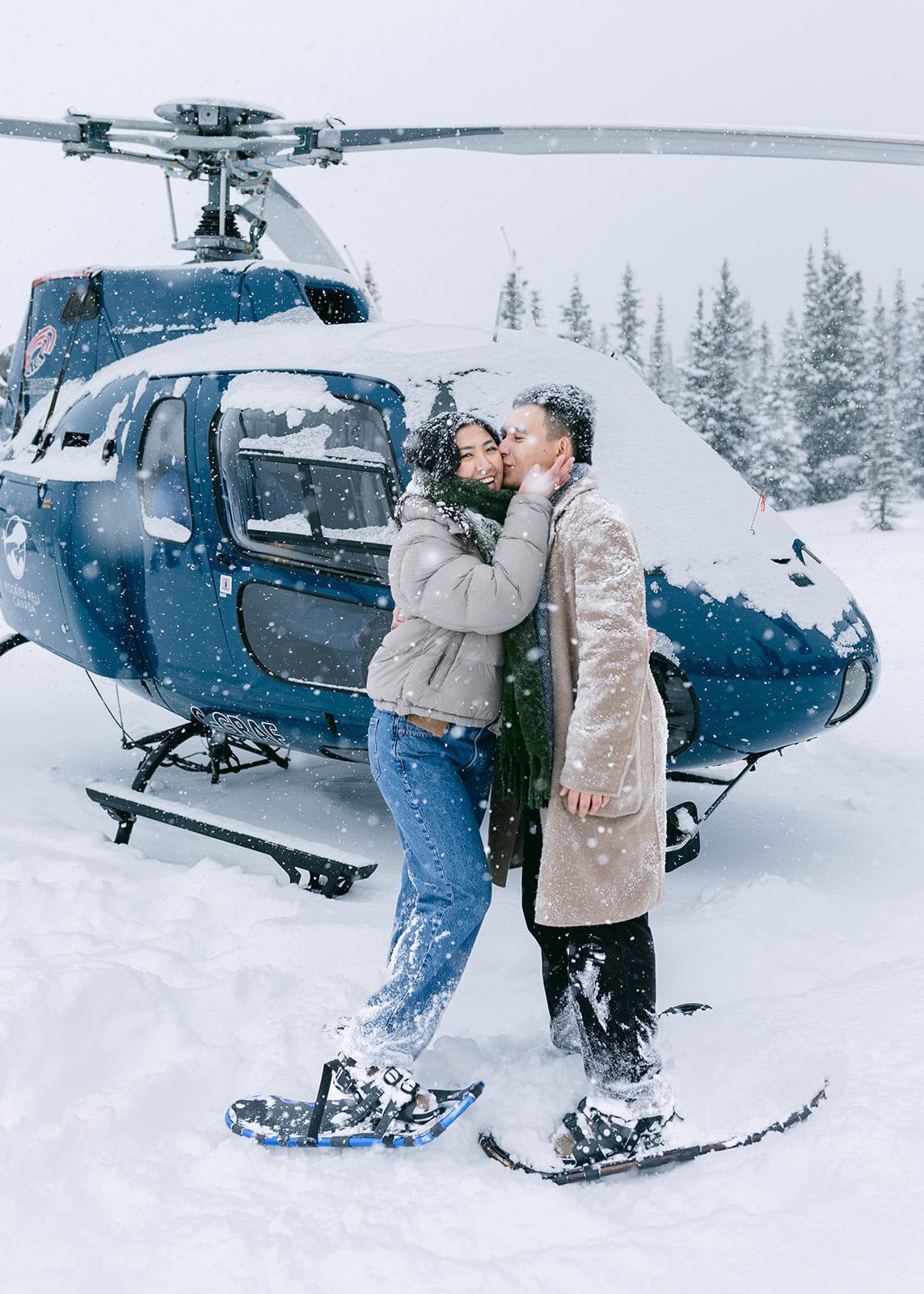 Winter Banff helicopter proposal in snowfall with whiteout conditions and limited visibility over the Canadian Rockies