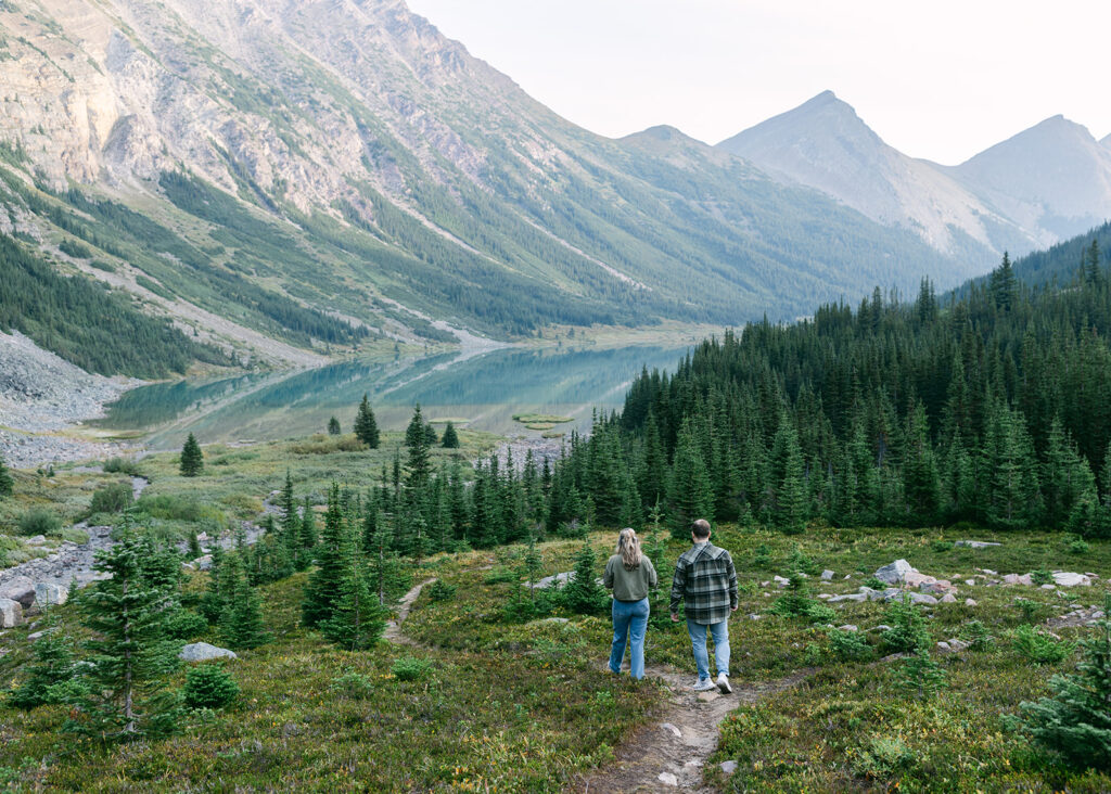 Sunrise heli proposal in Banff with soft light illuminating a couple on a secluded mountain summit