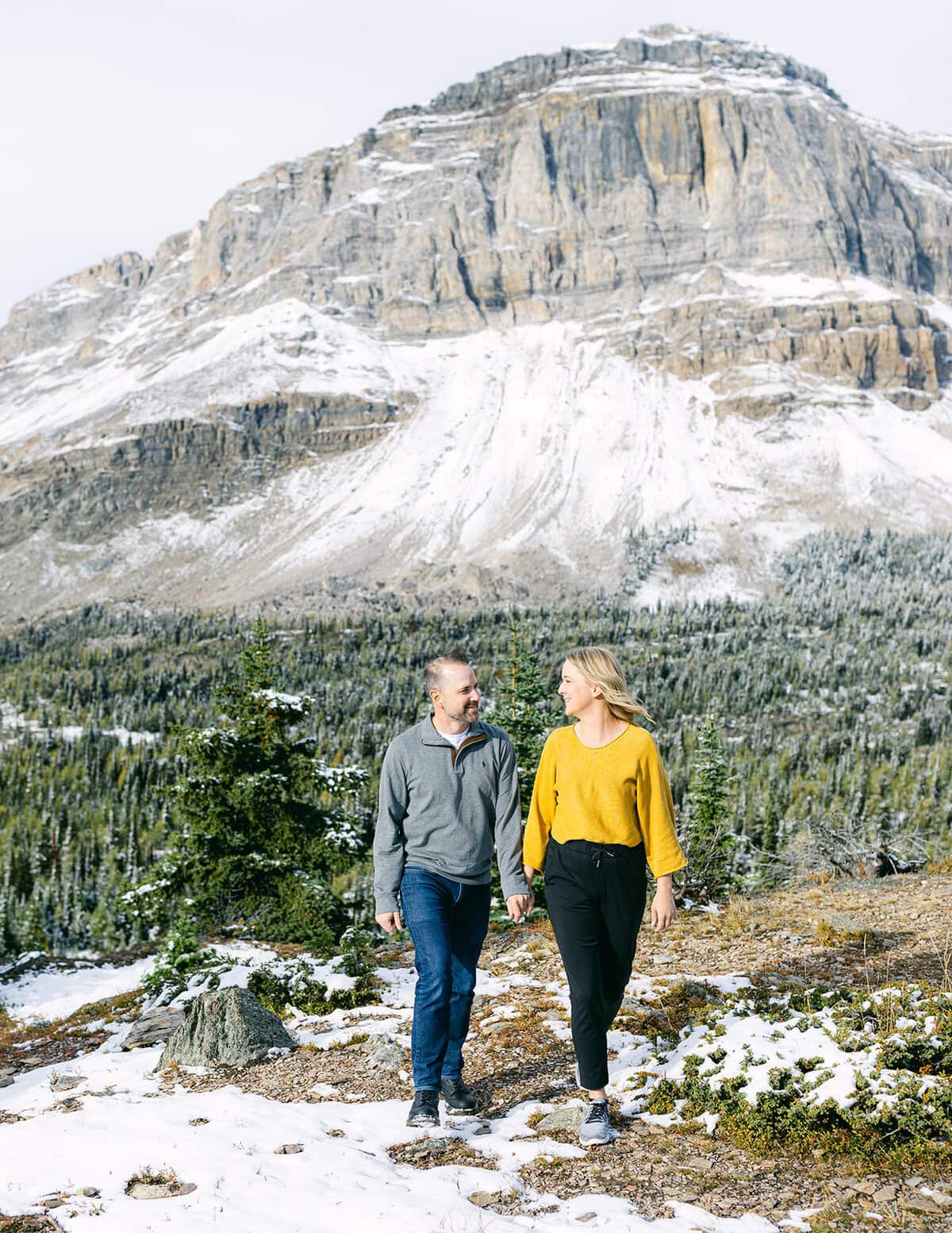 Couple engaged during an Alpine Helicopters proposal flight over the Rocky Mountains with patchy snow on peaks