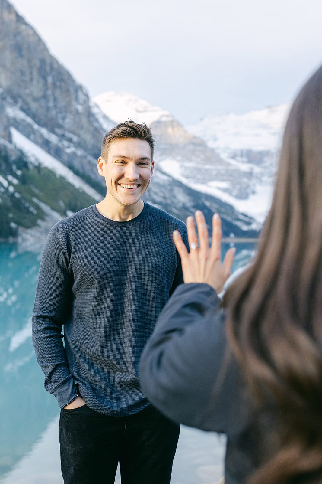 Romantic Lake Louise proposal in early October with turquoise water, fall foliage, and snow-dusted mountain peaks