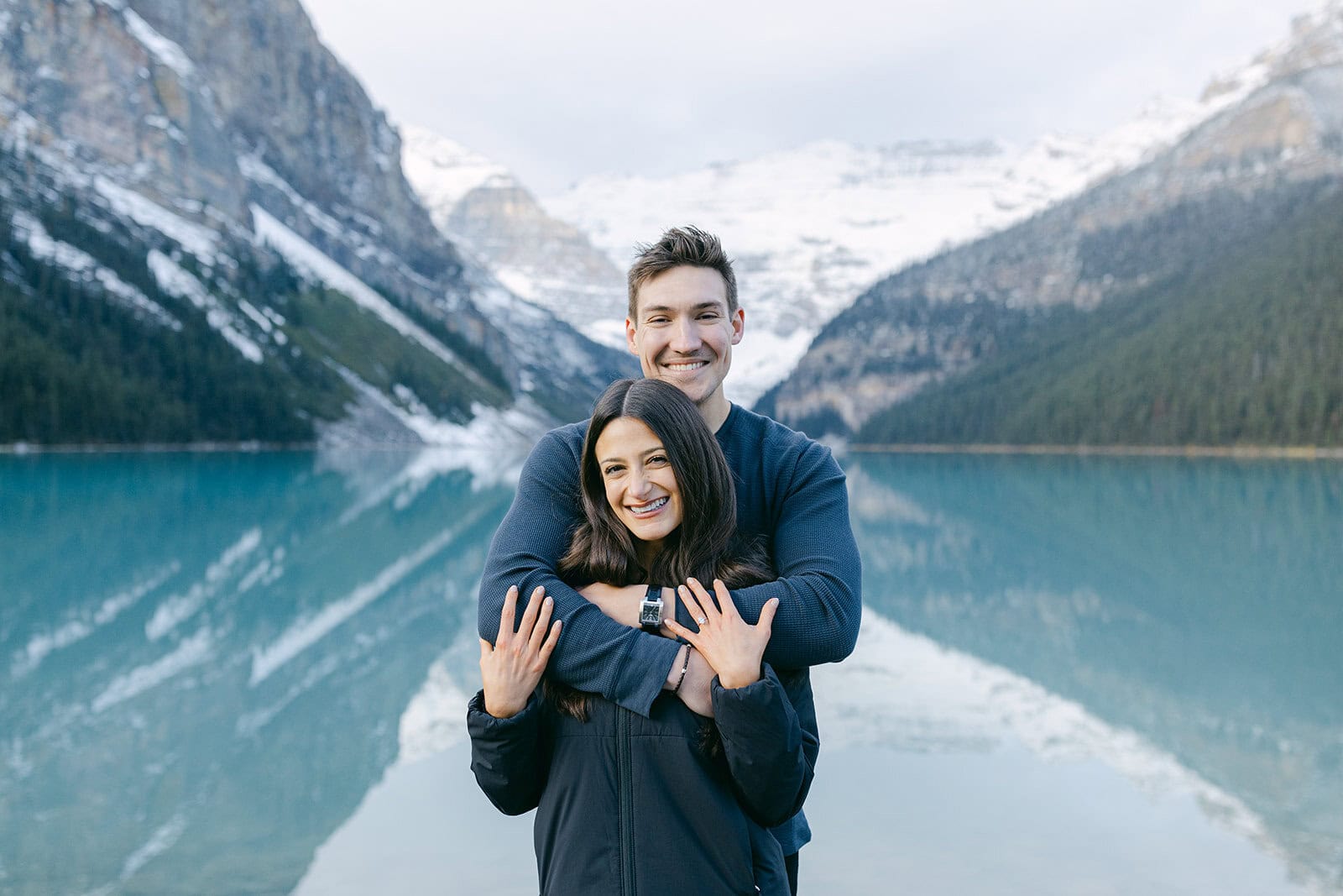 Intimate engagement at Lake Louise in early October with fall foliage and snow-capped Rocky Mountains