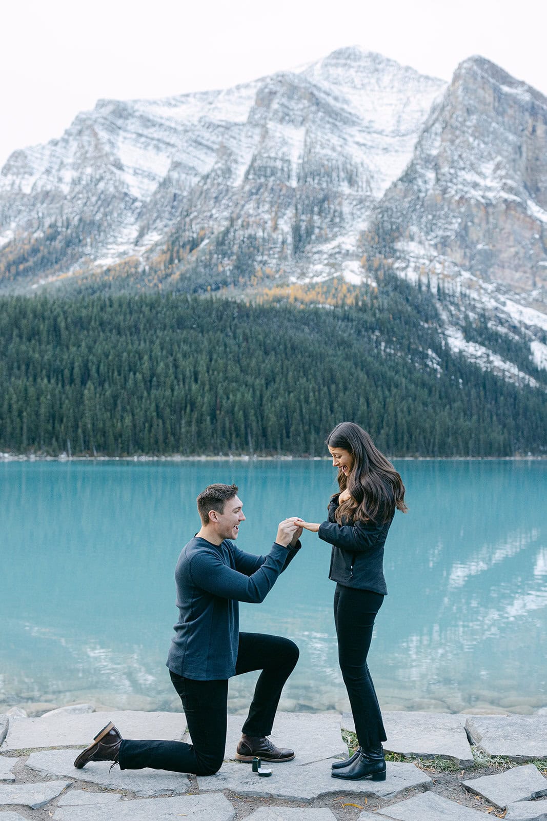 Emotional fall proposal at Lake Louise with vibrant autumn colours and lightly snow-covered peaks
