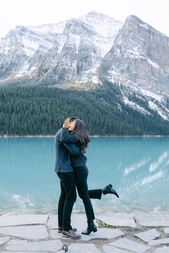 Cinematic early October proposal at Lake Louise with blue water, fall colours, and snowy alpine peaks