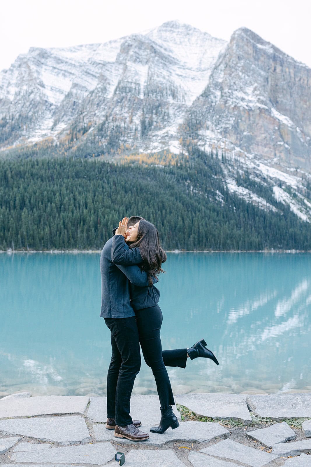 Cinematic early October proposal at Lake Louise with blue water, fall colours, and snowy alpine peaks