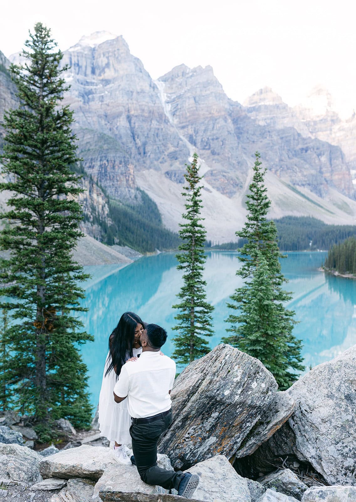 Couple celebrating a Moraine Lake proposal with breathtaking glacier-fed lake views