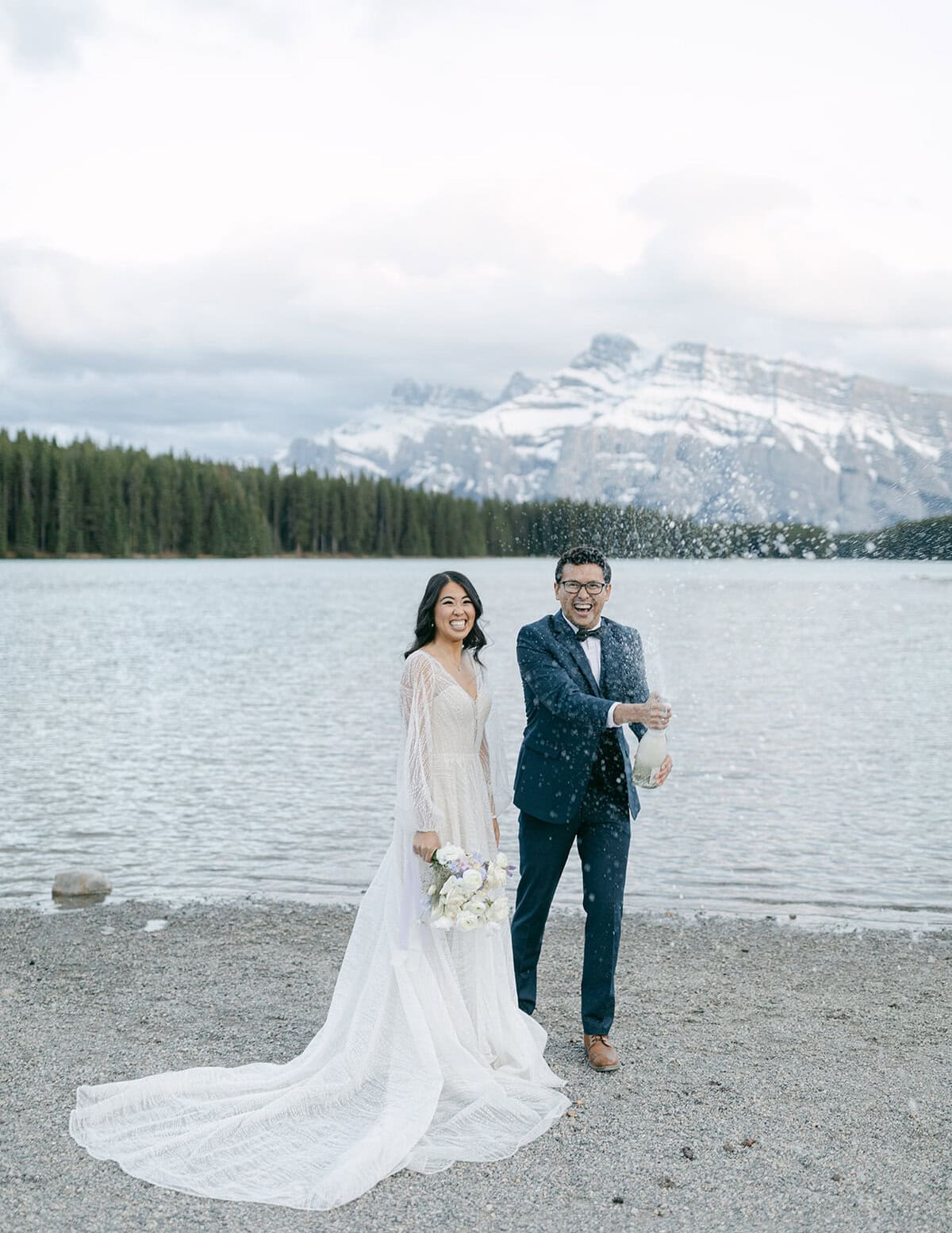 Lake Minnewanka elopement couple celebrating with champagne at Two Jack Lake