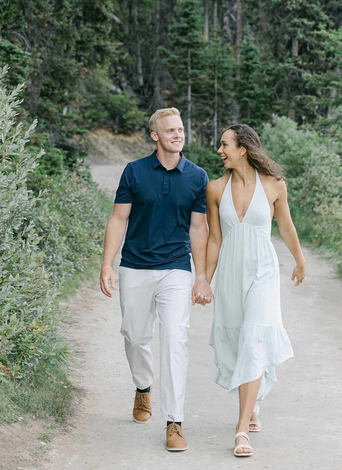 Couple walking along shoreline during Lake Louise engagement session in the Canadian Rockies