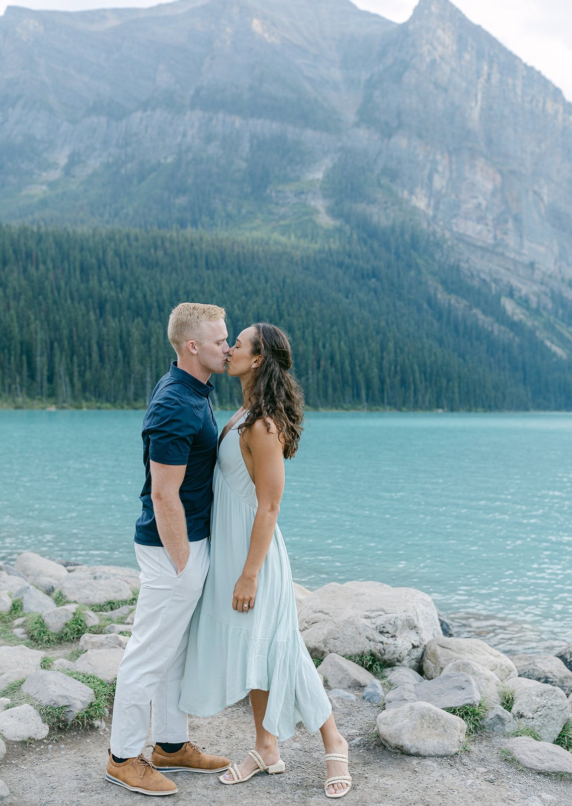 Couple sharing a kiss during Lake Louise engagement photos at sunrise