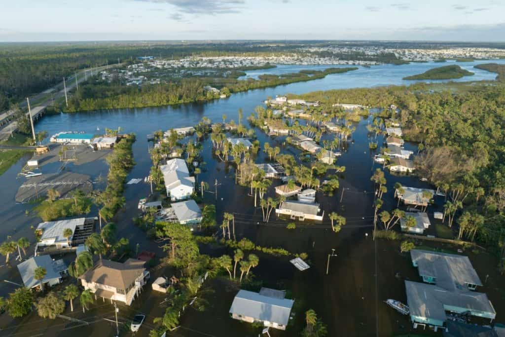 Aerial view of a flooded residential neighborhood with submerged homes and streets, highlighting the aftermath of severe flooding and the need for flood damage claims.
