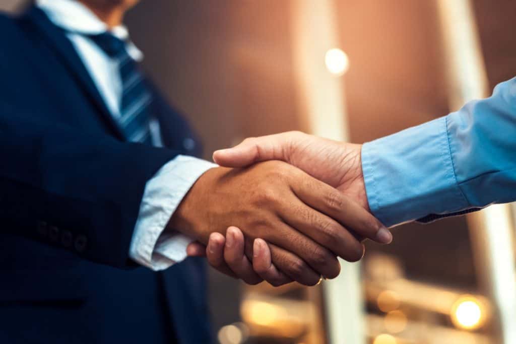 A policyholder shaking hands with an insurance attorney after a consultation regarding a property insurance damage claim.
