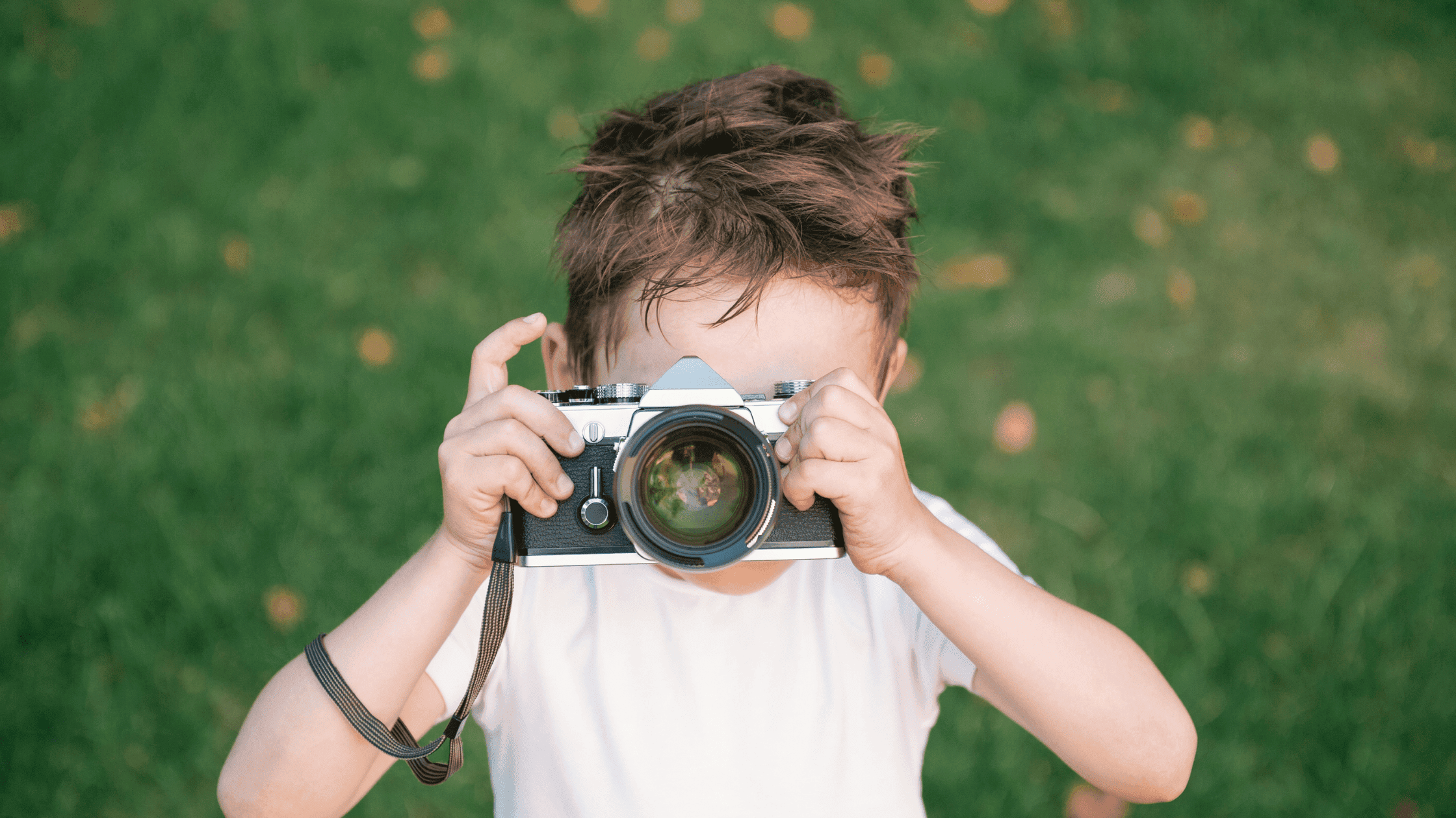 Boy using a vintage camera for documenting Montessori Family Summer Memories