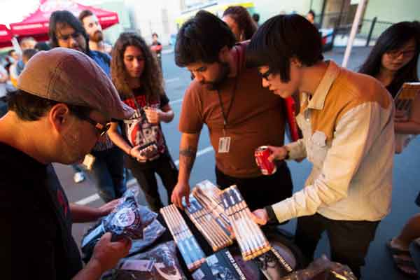 Musicians Institute students picking up items from a table