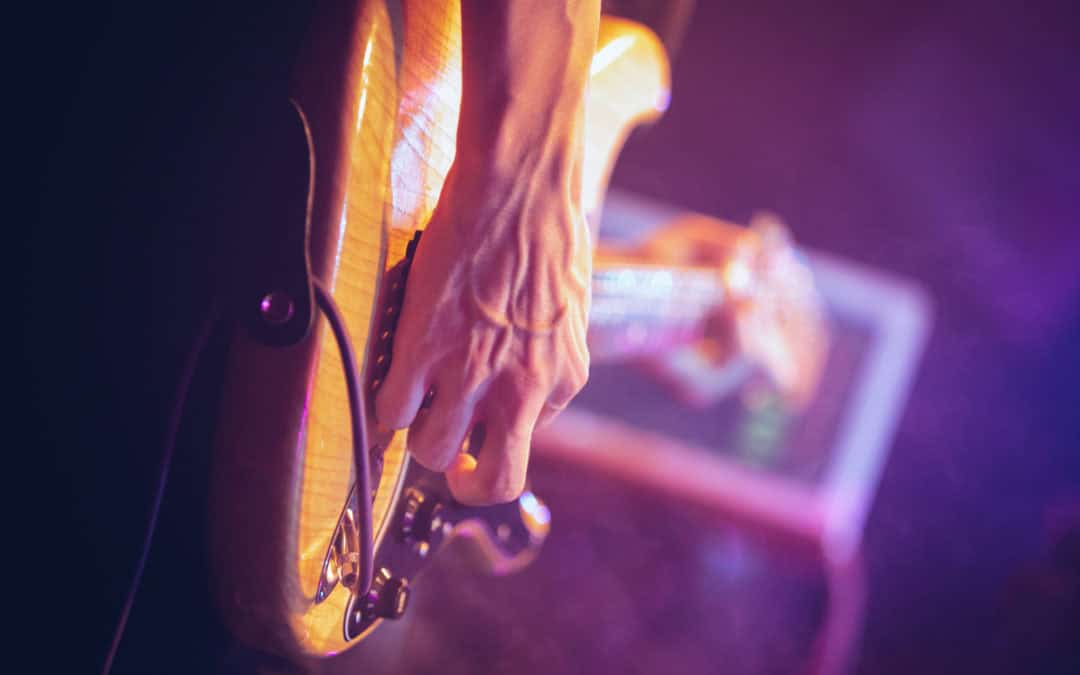 Professional guitarist plays solo part on electric bass guitar in nightclub