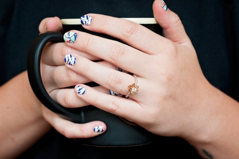 hands holding coffee cup wearing nail strips that make great stocking stuffers