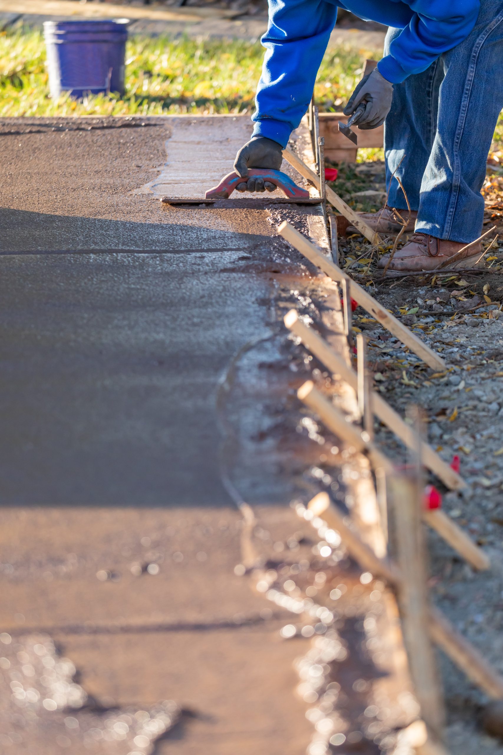 Construction Worker Smoothing Wet Cement With Trowel Tools