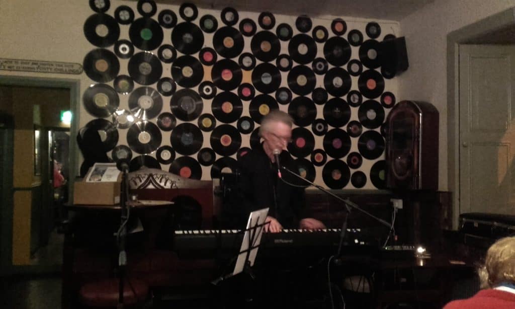 Donal Coghlan performing live at a music event in a cosy venue.
