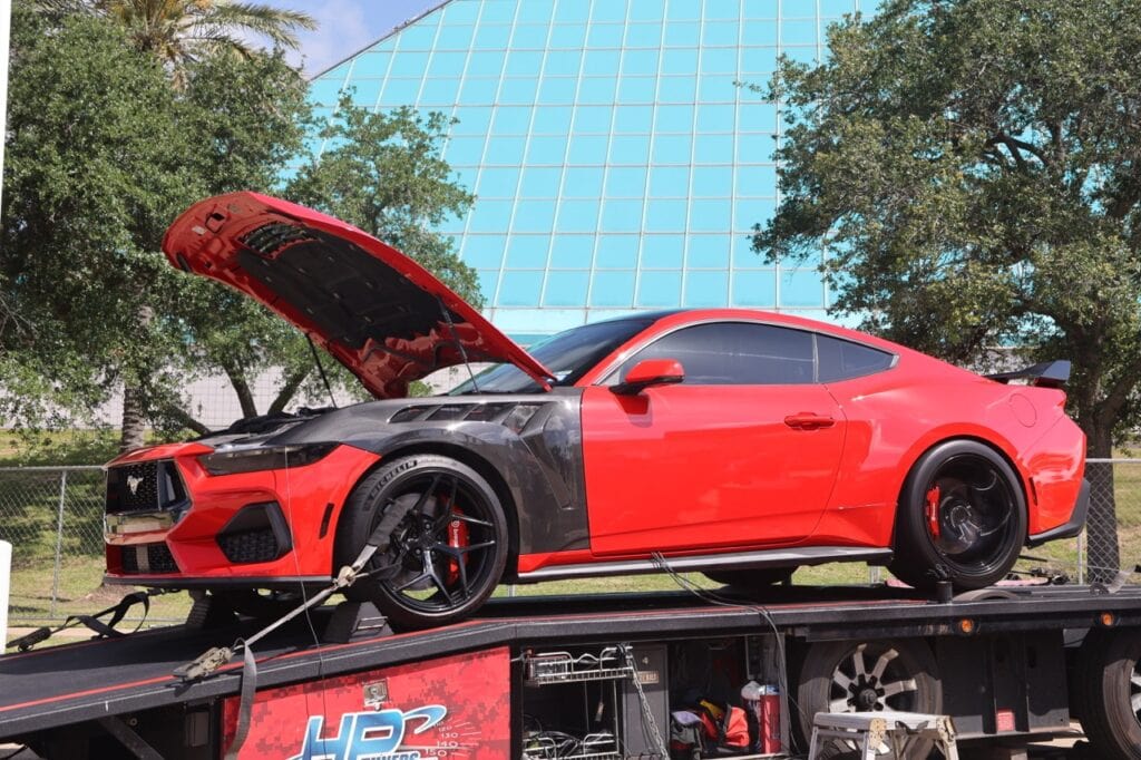 Red and black Ford Mustang on a trailer at Mustang Week Charlotte 2026.