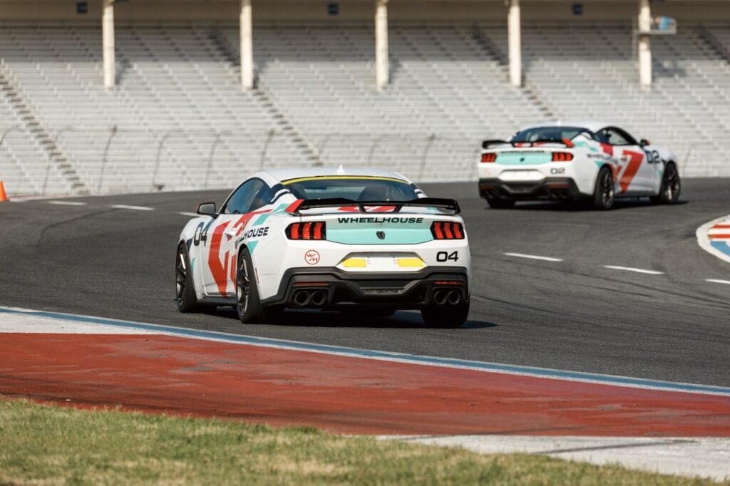 Two race cars on a track during Mustang Week event in Charlotte 2026.