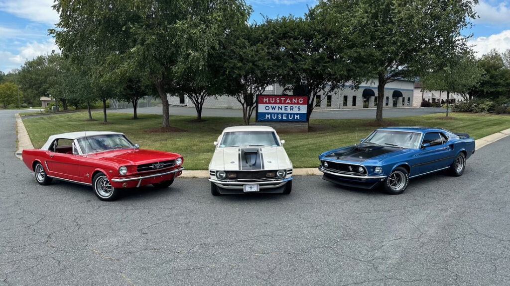 Three vintage Ford Mustangs parked outdoors during Mustang Week event.